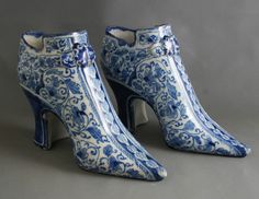 a pair of blue and white high heeled shoes with floral designs on the side