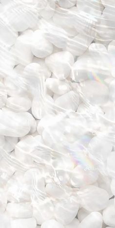 white pebbles in plastic wrap on top of each other with the sun shining through them