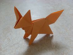 an orange origami cat sitting on top of a table