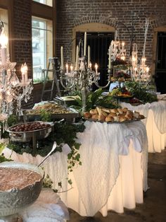 a buffet table is set up with many different foods and desserts on the tables