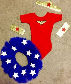 two baby onesuits with red, white and blue decorations on the floor next to each other