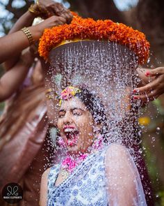 a woman is sprinkled with water from her head