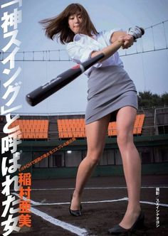 a woman holding a baseball bat on top of a field