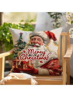 a christmas pillow sitting on top of a wooden chair next to a potted plant