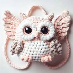 a crocheted owl with big eyes and wings on it's head is shown