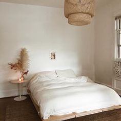 a white bed sitting in a bedroom next to a window