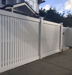 a white picket fence in front of a house