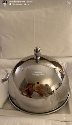 a woman taking a selfie in the mirror of a silver platter