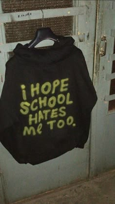 a black hoodie that says i hope school hates me too hanging on a door