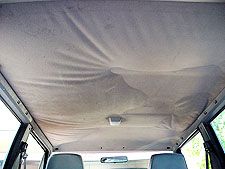 the inside of a van with no roof and two seats in it, covered by a tarp