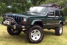 a green jeep is parked in the grass