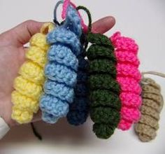 four crocheted objects are being held by someone's hand