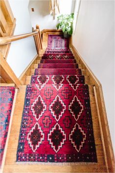 a red rug is on the floor next to stairs