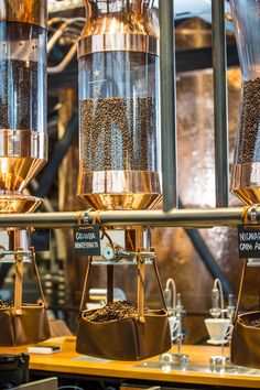 three coffee grinders filled with different types of coffee beans and grains on top of each other