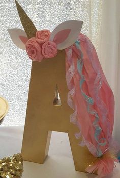 the letter a is decorated with pink flowers and gold sequins in front of a glitter background