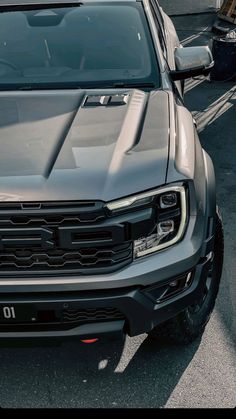 the front end of a silver truck parked in a parking lot