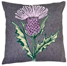 an embroidered thistle flower on a gray pillow