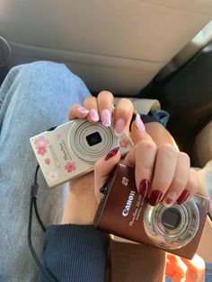 a woman is holding a camera and taking a photo in the back seat of a car