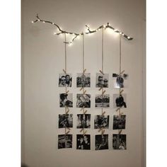 several pictures are hung on the wall with twine and lights strung from each string