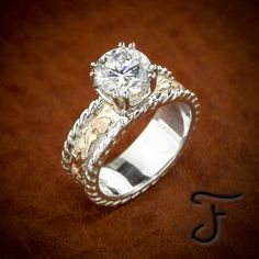 a diamond ring on top of a brown leather surface with the initials j and j