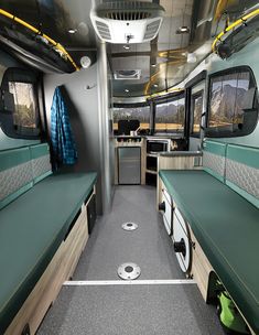 the interior of an rv with green counters and blue towels hanging from the ceiling,