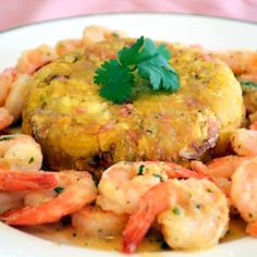 a white plate topped with food covered in sauce and garnished with cilantro