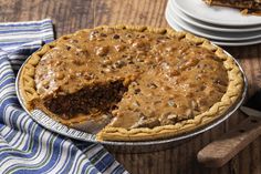 a pie sitting on top of a wooden table with a slice cut out of it