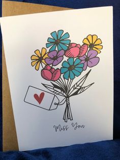 a card with flowers and a heart on it that says miss you in the center