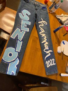 the jeans have been decorated with white letters and numbers on them, along with other items