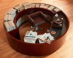 a round table with books and magazines on it in the middle of a wooden floor