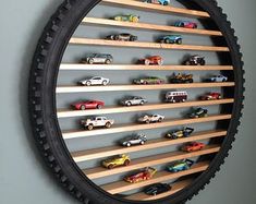 a wall mounted toy car display in a circle shaped frame with wooden slats on the sides