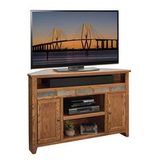 a flat screen tv sitting on top of a wooden entertainment center cabinet with doors open