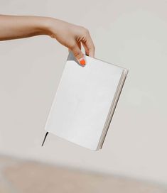 a woman's hand holding an open book over a white background with copy space