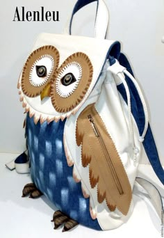 an owl purse is sitting on top of a white surface with the words atenleu written above it