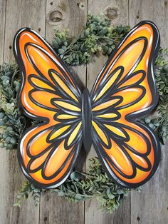 an orange and black butterfly sitting on top of a wreath