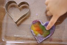 someone is decorating a heart shaped cookie