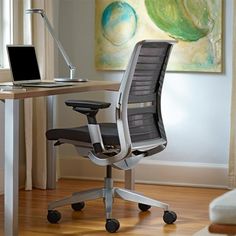 an office chair sitting in front of a desk with a laptop on it