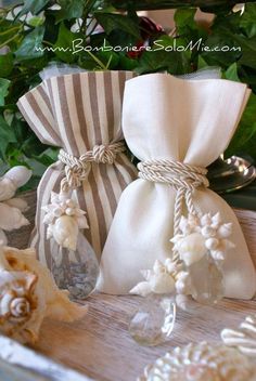 two bags with flowers tied to them are sitting on a table next to some silverware