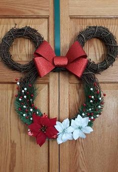 a mickey mouse wreath with red bow and poinsettis on the front door