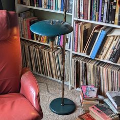 a red chair sitting in front of a bookshelf filled with lots of books