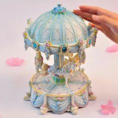 someone is holding the top of a small carousel