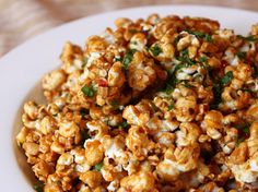 a white plate topped with popcorn covered in cheese