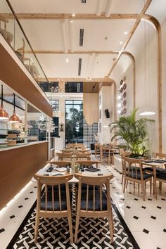 the interior of a restaurant with wooden tables and chairs, black and white patterned floor