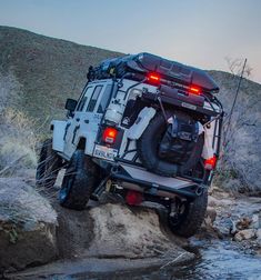 an off - road vehicle is parked on the side of a stream