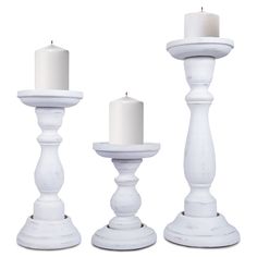 three white candles sitting next to each other