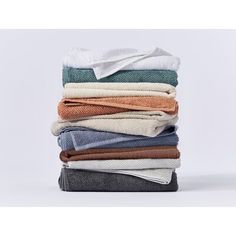 folded towels stacked on top of each other in various colors and sizes, all with one folded towel