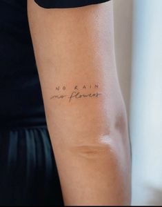 a woman's arm with the words no rain, no flowers written on it