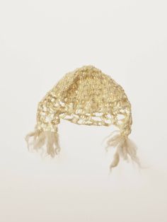 a gold hat with white feathers hanging from it's brimmings on a white background