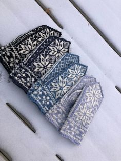 four knitted ties laying on top of snow covered ground