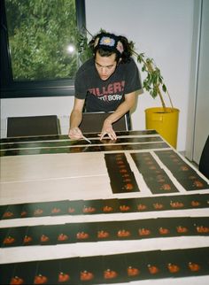 a man standing over a table that has pictures on it